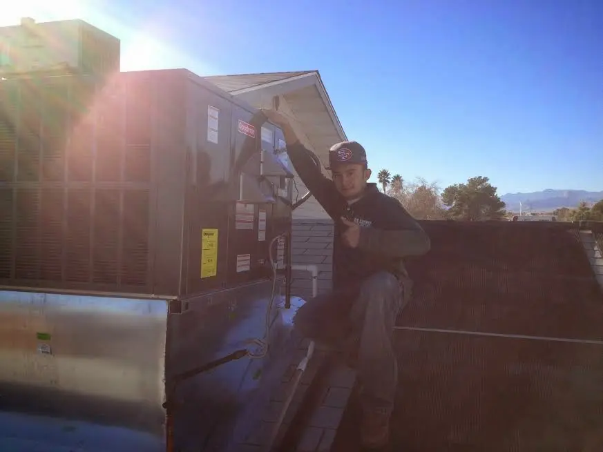 HVAC technician performing HVAC Inspection on a rooftop unit in Amityville